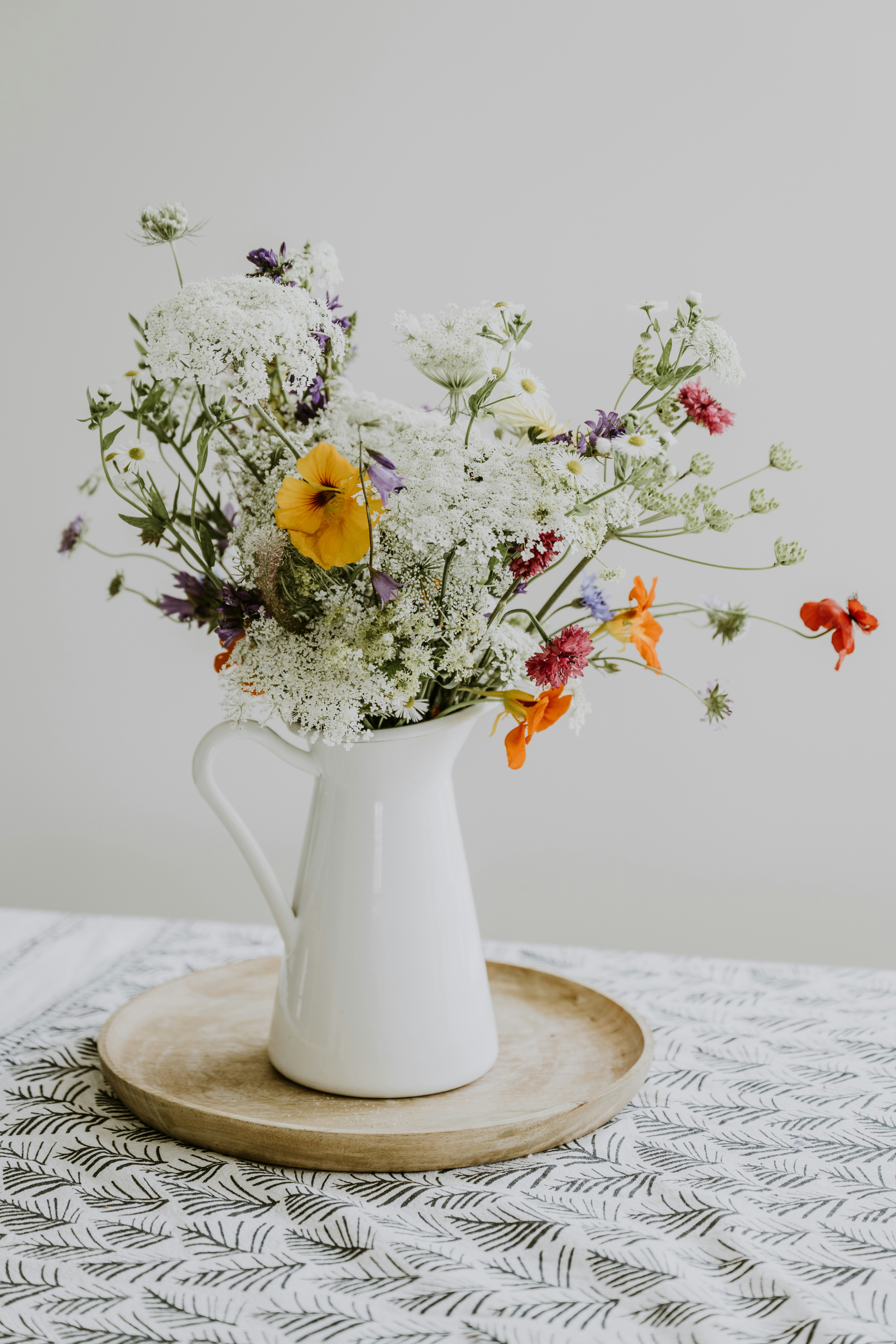 A vase with yellow, red, purple and white flowers.